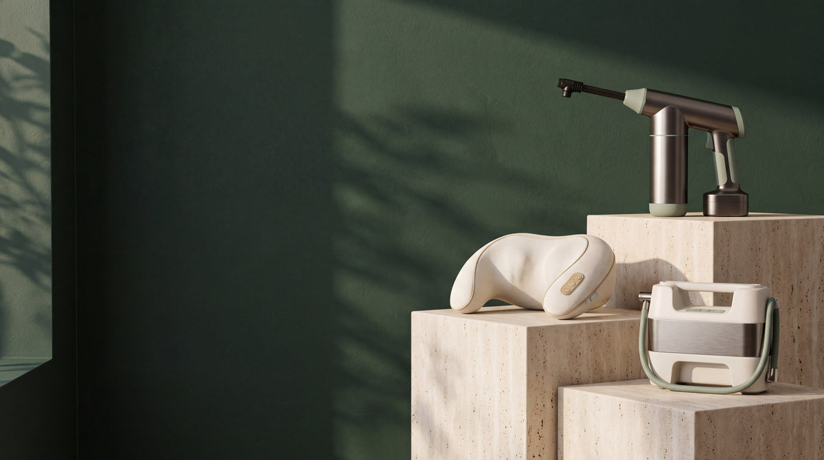 The Everhandy pressure washer, neck and shoulder massager and tire inflator on travertine plinths in a forest-green room