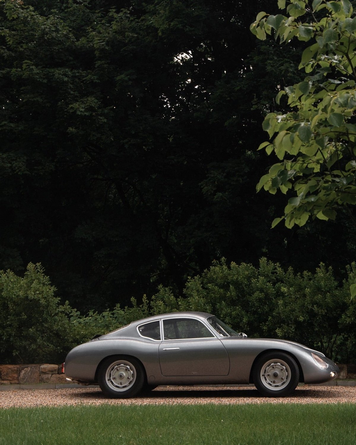 A clean silver car parked on a quiet green country road