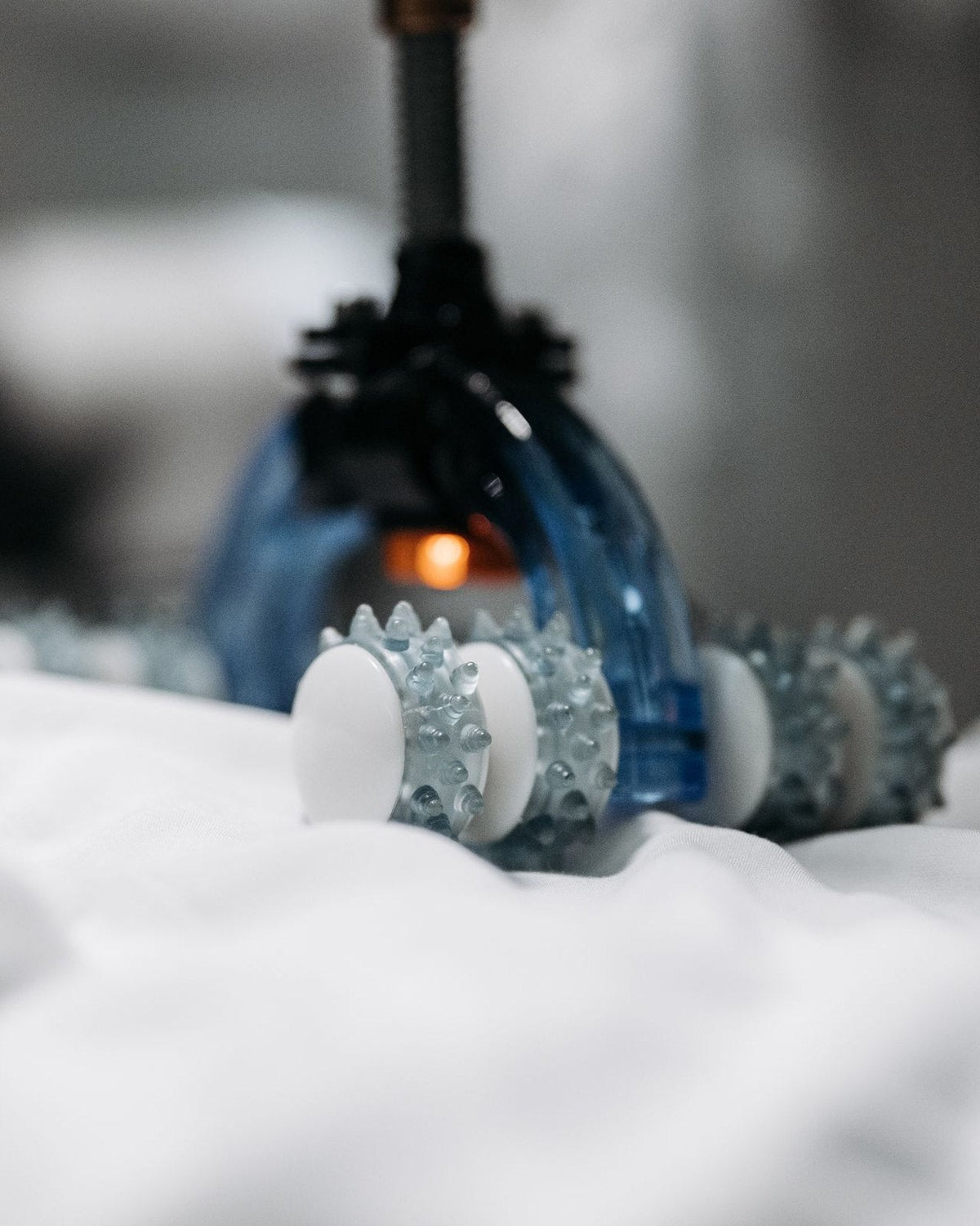 Massage device resting on soft white fabric