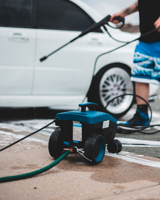 Pressure washer in use on a car driveway